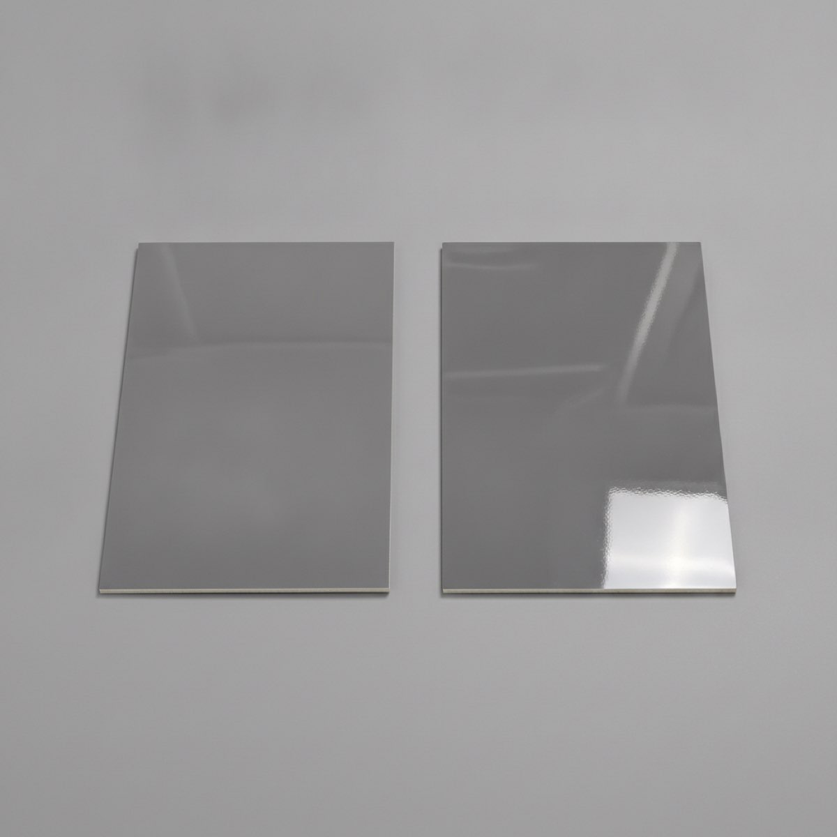 Two grey resin finish samples side by side showing a softer satin sheen next to a harder glossy sheen