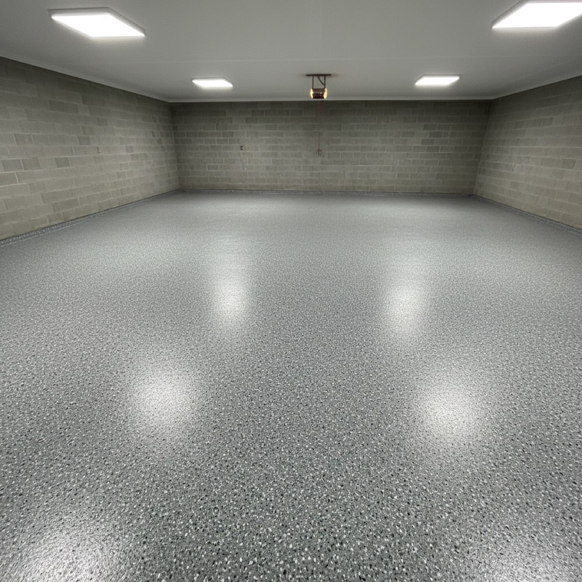 Garage floor finished in a grey flake epoxy resin, showing the speckled textured surface