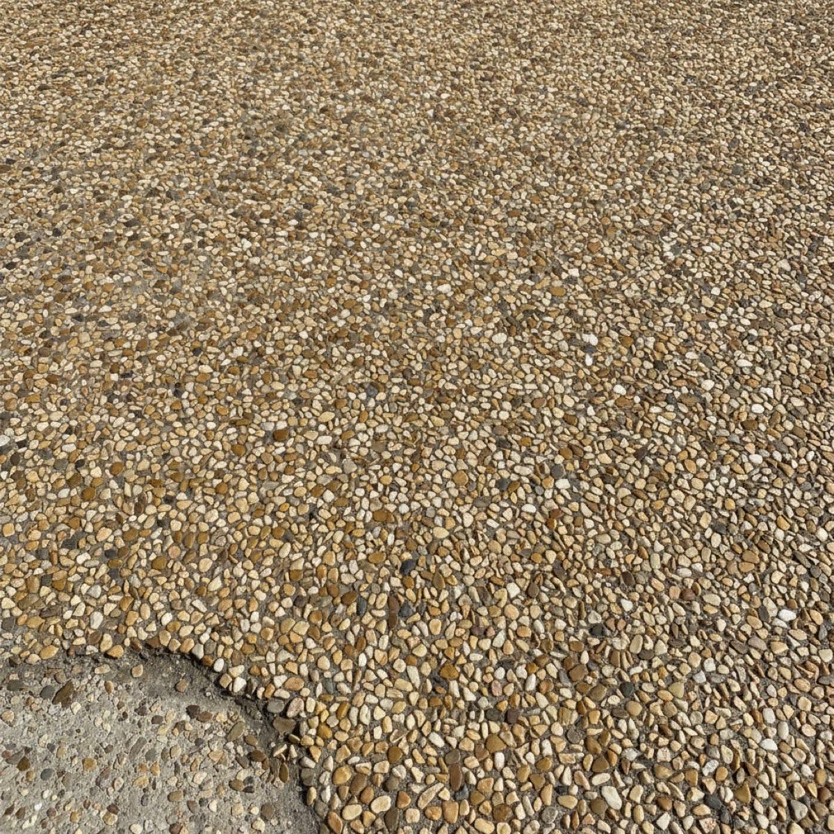 Close-up of a resin-bound driveway surface showing natural wear and stone loss at a worn edge